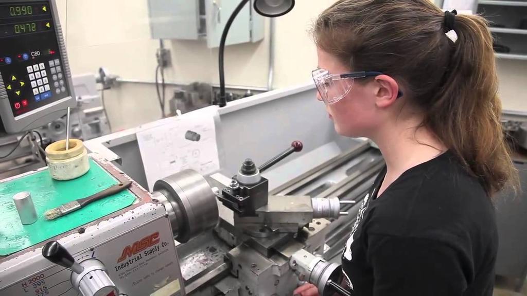 A student uses a machine in a mechanical shop.